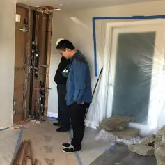 Two men looking at construction in a motel room being remodeled for housing.