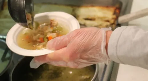 Server ladles soup into a bowl