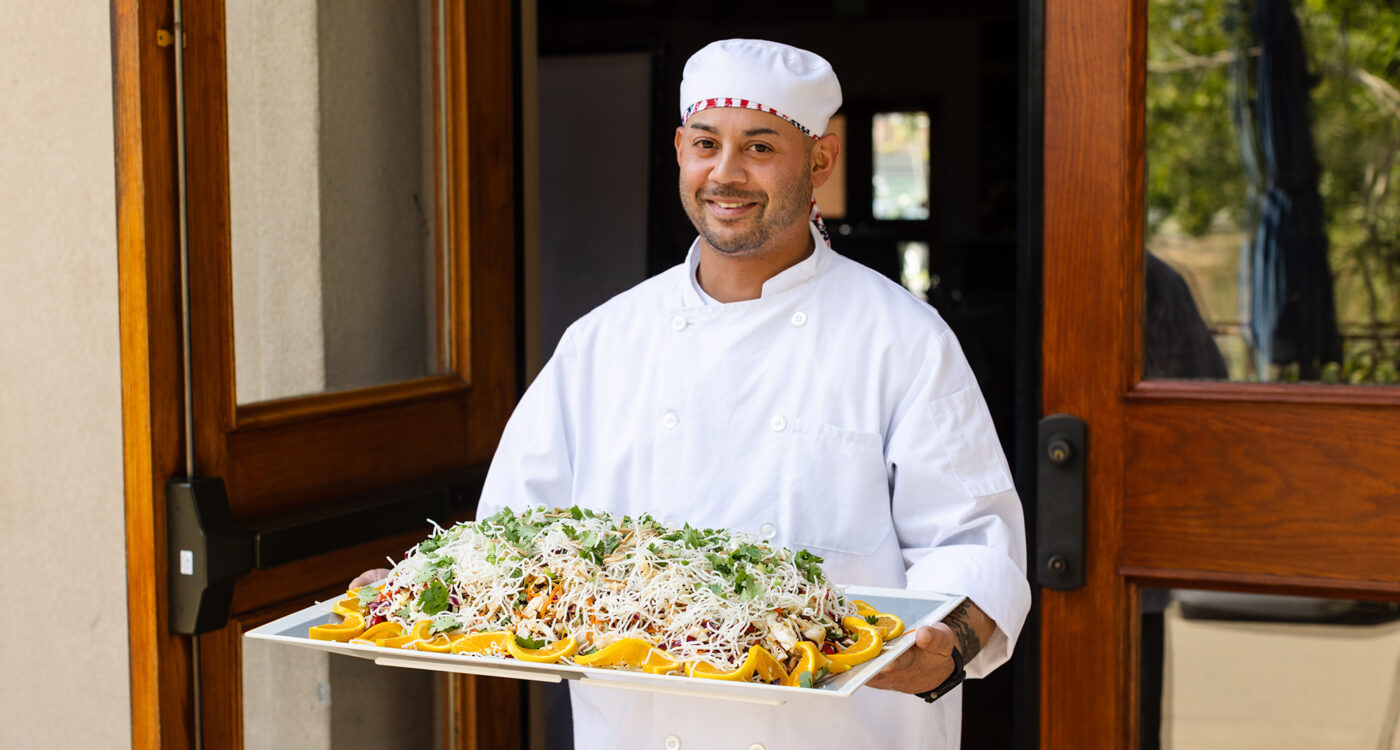 a chef holds a large tray of food