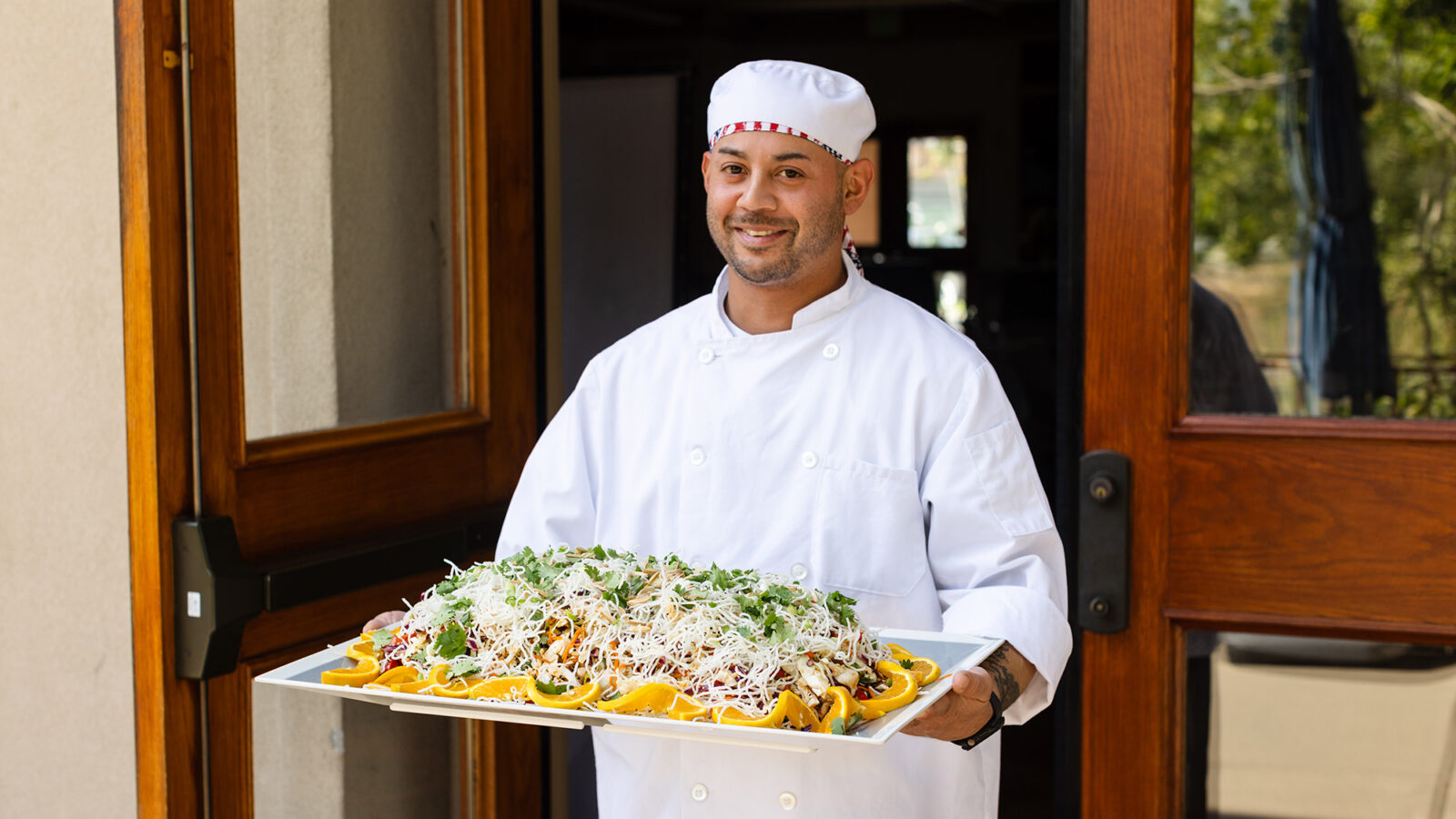 a chef holds a large tray of food