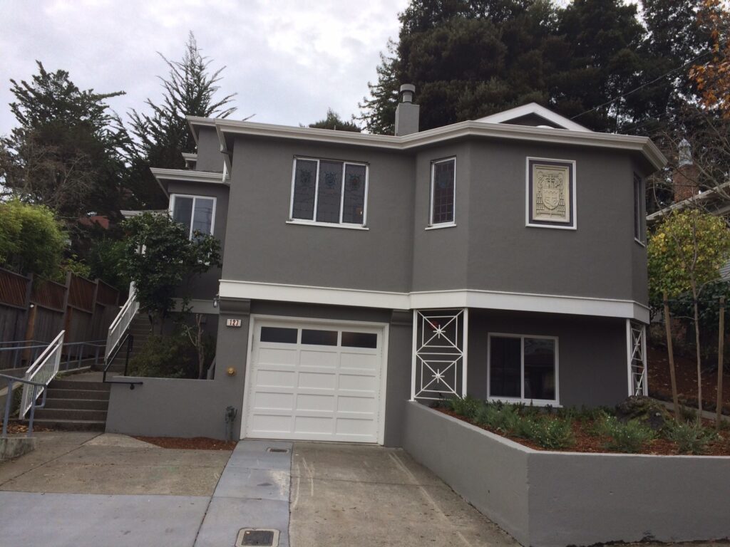 exterior of a grey, two story house with white garage