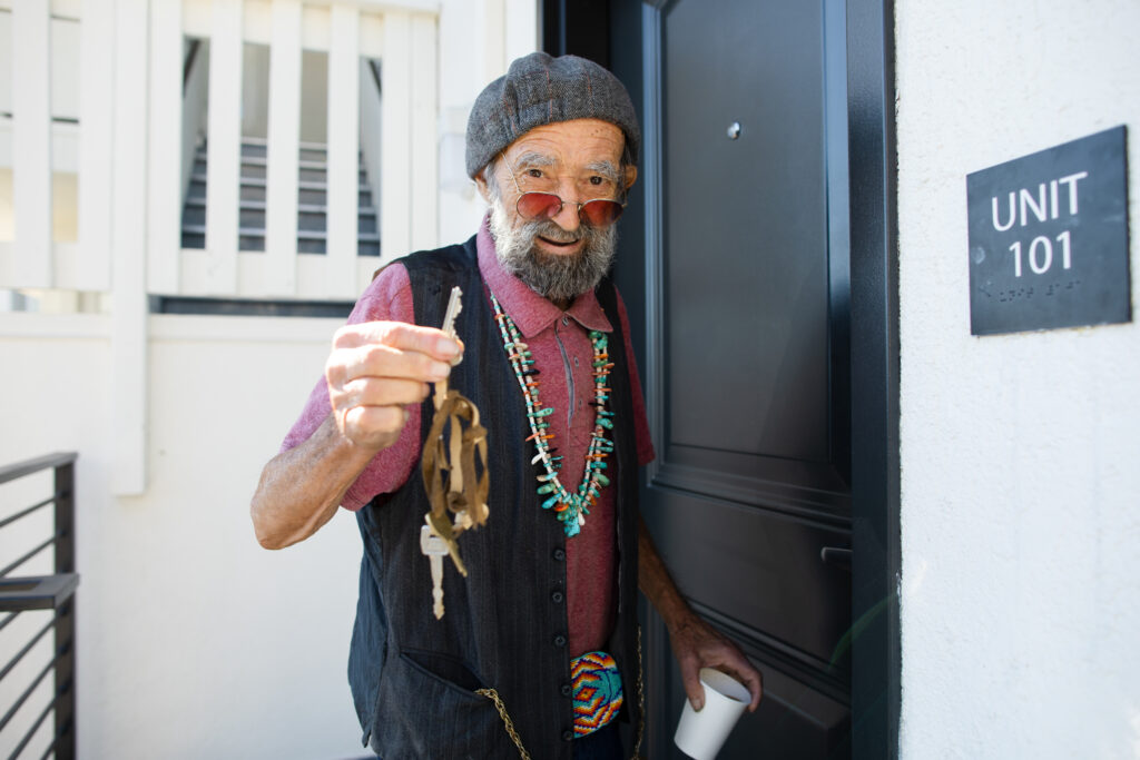 Albert holding up a set of keys in front of a door