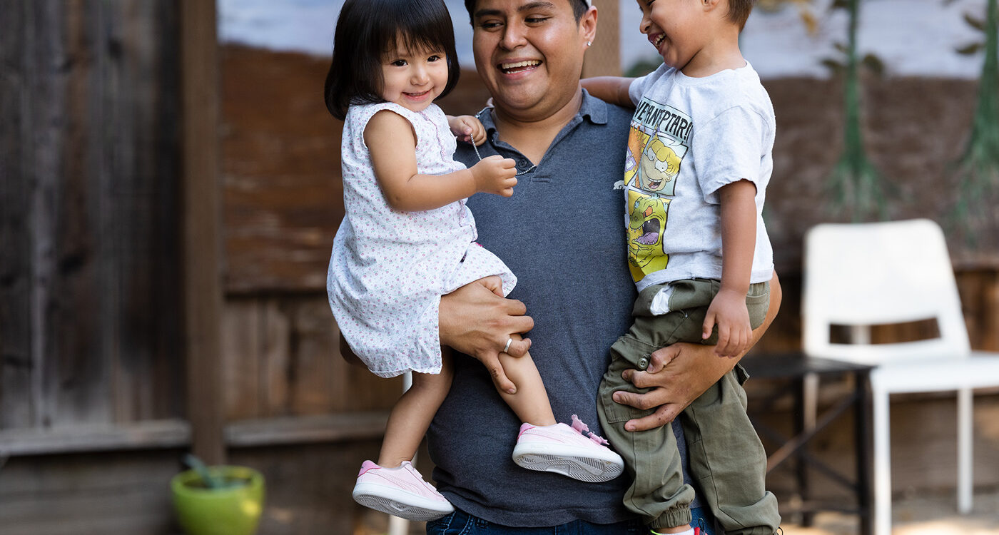 A man holding two toddlers