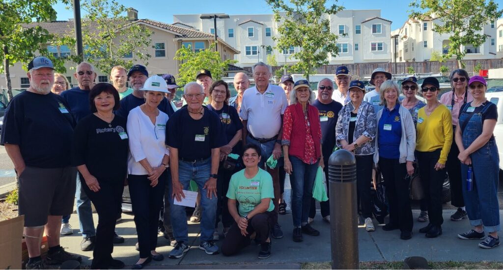 Group of volunteers gathers in front of veterans housing.