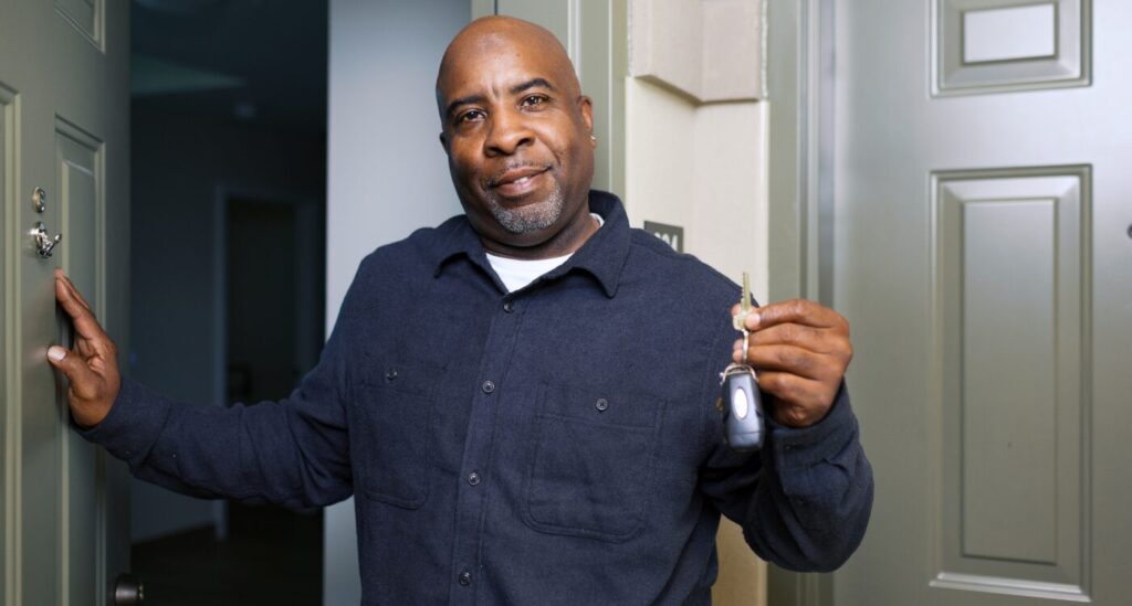 Black man stands at apartment door holding his keys