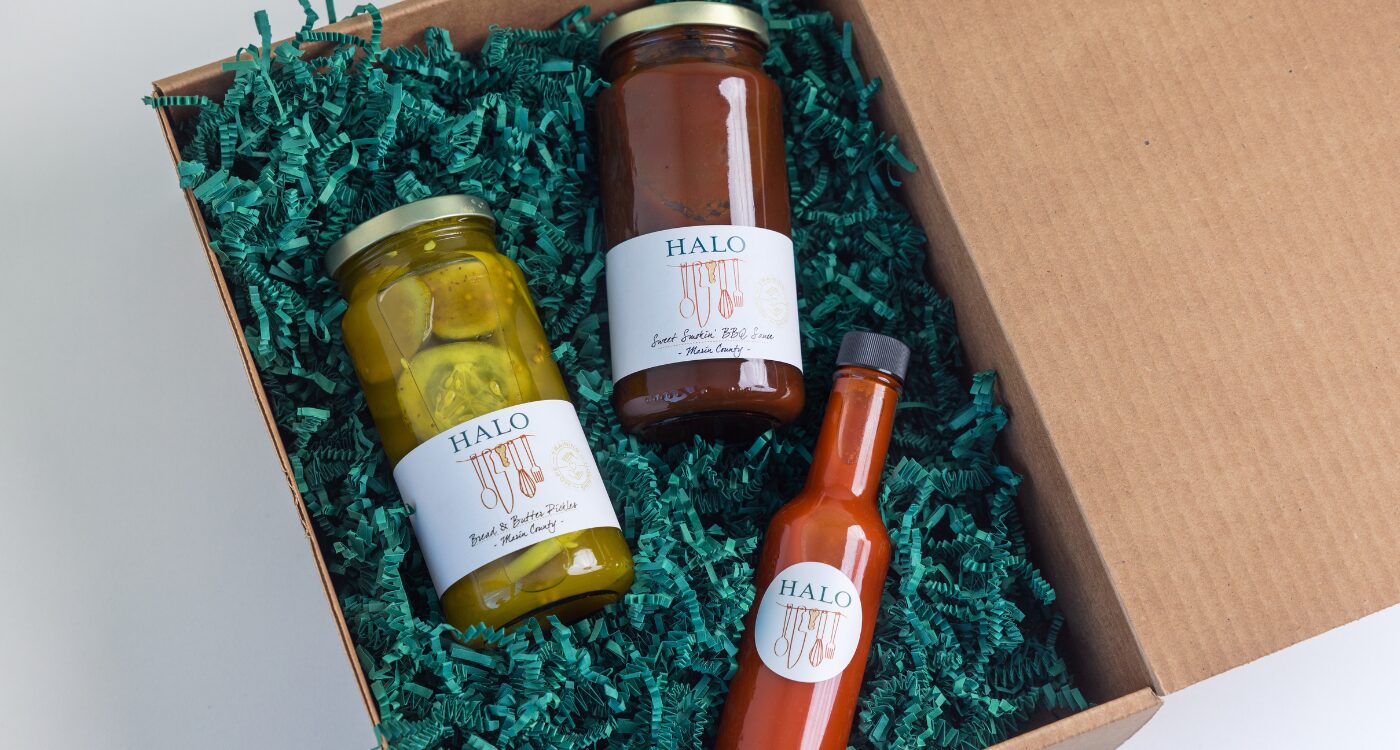 Jar of pickles, barbecue sauce and hot sauce in a box