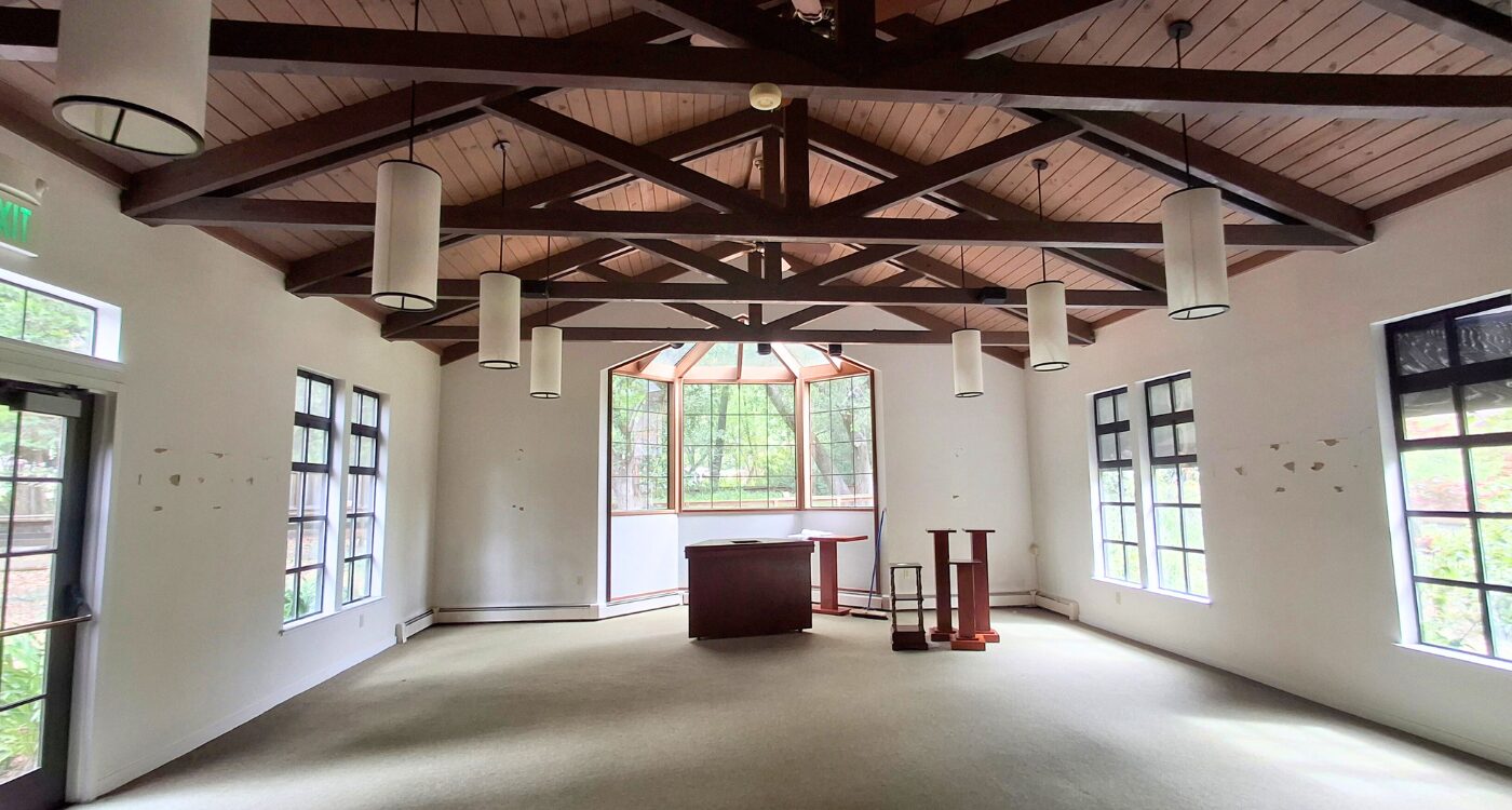 Small chapel with white walls and dark wood beam ceiling