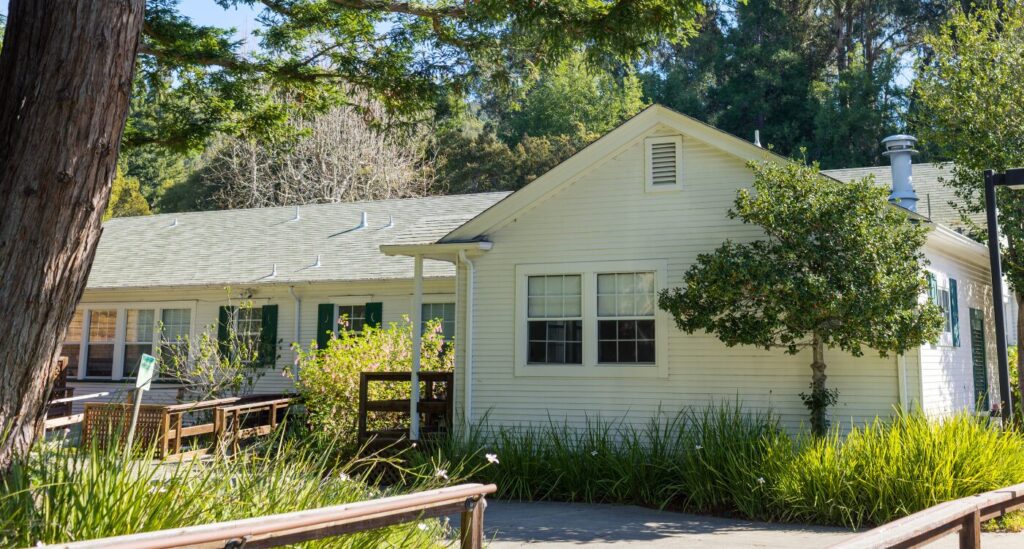 One story white building with garden around it
