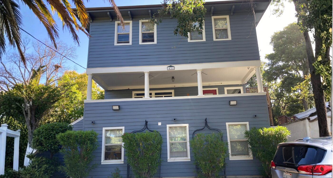 Blue shingled house with white trim and porch columns